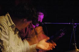 A close of of brian clapping the bulerias rhythm with steven spungin behind playing guitar. the image of my hands is blurry and was filmed with slow shutter speed.