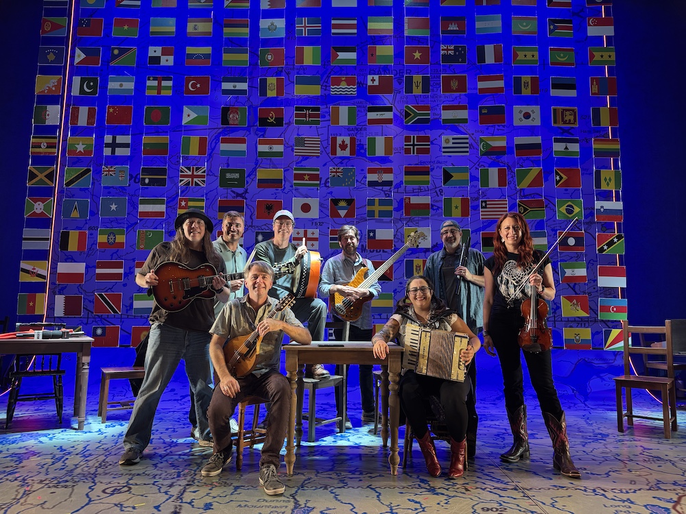 The band poses on stage for Come From Away at Cape Playhouse in costume